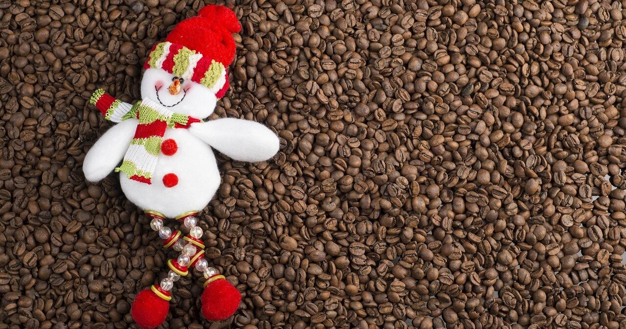 koffiebonen met een sneeuwpop verkleed als kerstman